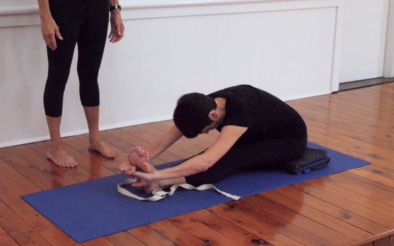 Paschimottanasana with a Rolled Towel Under Coccyx pose