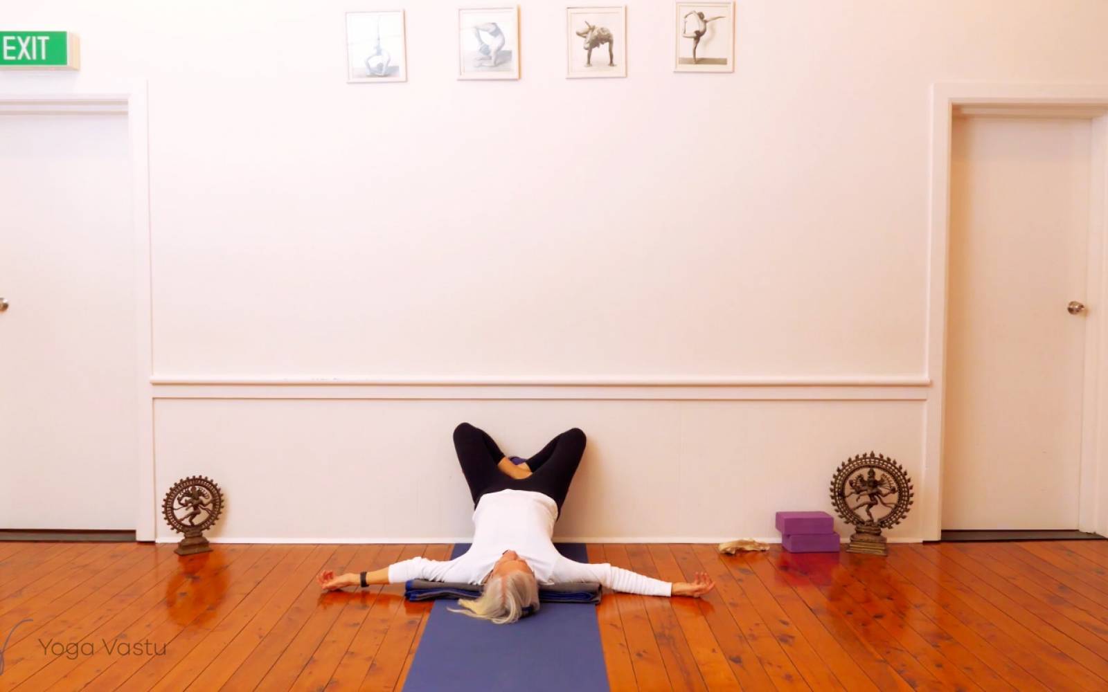 Premium Photo | Woman performs a difficult yoga asana, standing on a mat  against a background of a yellow wall